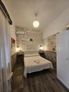 een slaapkamer met een bed en een bakstenen muur bij Recuerdos de la Abuela in Sevilla