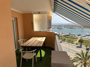 a balcony with a table and chairs and a view of the water at La Manga del Mar Menor, Los Miradores del Puerto in La Manga del Mar Menor