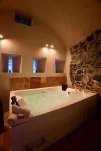 a large bath tub in a bathroom with a mirror at Les Secrets du Fort - Love Room unique in Albertville