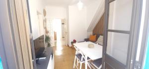 ナザレにあるCasa Pisa Flores - Praia da Nazaréの白いテーブルと部屋のある小さなアパート