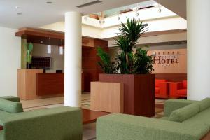 una hall con sedie verdi e una sala d'attesa di Hermes Hotel a Policoro