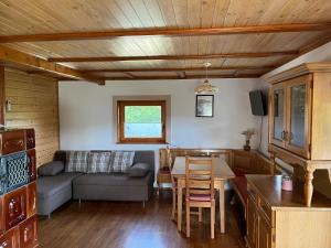 a living room with a couch and a table at Sedmakovo - Počitniška hiša v naravi - Ljubno ob Savinji in Ljubno
