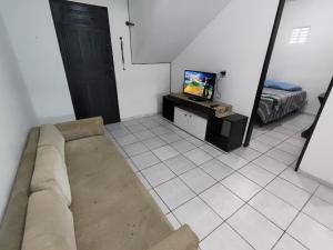 a living room with a couch and a tv at Ap 2 quartos com vaga de garagem in Campina Grande