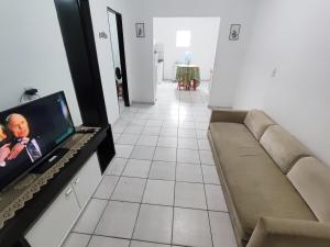 a living room with a couch and a flat screen tv at Ap 2 quartos com vaga de garagem in Campina Grande