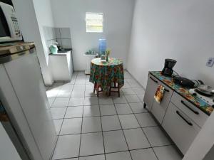 a kitchen with a table and a kitchen with a stove at Ap 2 quartos com vaga de garagem in Campina Grande