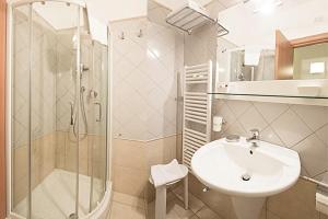 un bagno con lavandino, doccia e WC di Hermes Hotel a Policoro