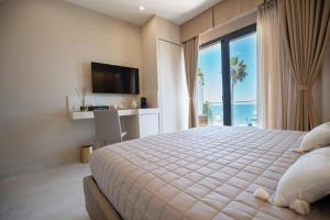 a bedroom with a large bed with a view of the ocean at Nery Home Luxury Sea View Giardini Naxos in Giardini Naxos