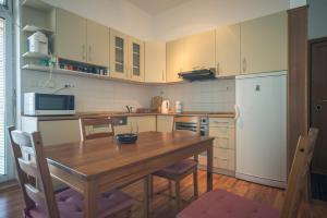 a kitchen with a wooden table and a refrigerator at Apartment Kruna Center in Podgorica