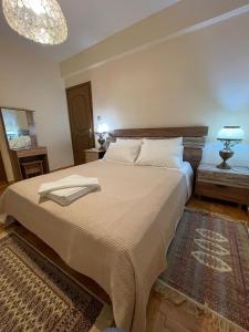 a bedroom with a large bed and a chandelier at Aelia Seaside Maisonette in Neoi Epivates