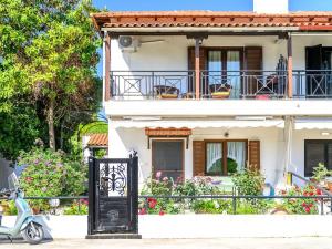 a white house with a scooter parked in front of it at Aelia Seaside Maisonette in Neoi Epivates +10 photos