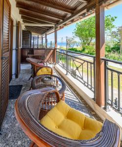 a balcony with wicker chairs and tables and views of the ocean at Aelia Seaside Maisonette in Neoi Epivates