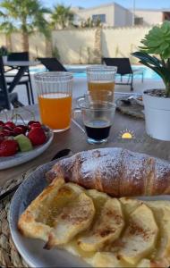 a table with a plate of food with toast and drinks at Limonaia Luxury Villa in Porto Empedocle