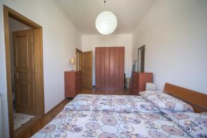 een slaapkamer met een groot bed met een sprei erop bij Apartment Kruna Center in Podgorica