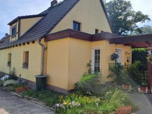 a yellow house with a black roof at Unterkunft Mohr in Schmerwitz +9 photos