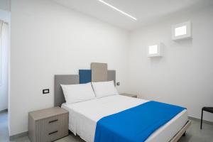 een slaapkamer met een groot bed met blauwe en witte lakens bij Nonna Anna in Castellammare di Stabia