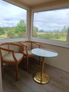 a room with two chairs and a table and a window at Kalna Raskumu Apartamenti in Vecpiebalga