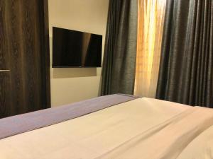 een slaapkamer met een bed en een flatscreen-tv bij Ringruby Hotel, Oduduwa Way in Ikeja +14 foto's