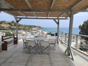 a patio with a table and chairs and the ocean at Alkinoi studio suita in South Crete Tsoutsouros in Tsoútsouros