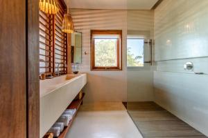 a bathroom with a tub and a sink and a mirror at Villa Mandi in Jericoacoara
