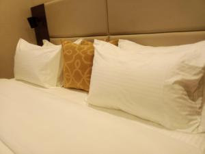 a bed with white pillows and white pillows at Ringruby Hotel, Oduduwa Way in Ikeja