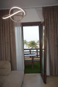 a living room with a chandelier and a door to a balcony at Segal Hawana Salalah 2 Bedroom Marina in Salalah