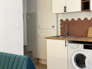 a kitchen with a washing machine and a sink at Charming Cozy Cottage Palaiseau Center in Palaiseau +4 photos