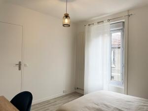 a white bedroom with a bed and a window at Charming Cozy Cottage Palaiseau Center in Palaiseau