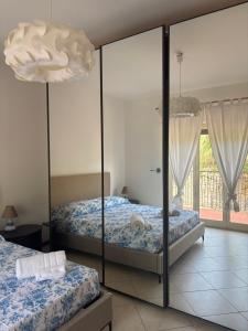 a bedroom with two beds and a mirror at Heliomar Naxos - Your Balcony on the Sea in Giardini Naxos