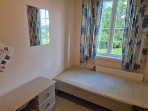 a small room with a bed and a window at Frogner Hovedgård in Skien