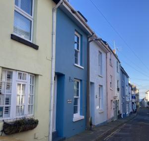 a row of colourful houses on a street at Fisherman's Cottage - Harbour Close, Pub Closer, Sea Views if You Look Hard in Brixham