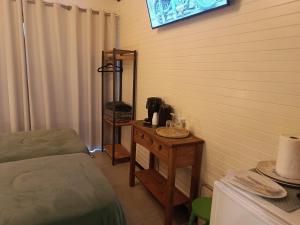 a room with a bed and a table with a coffee maker at Cabana Sesteo in Iomerê +14 photos