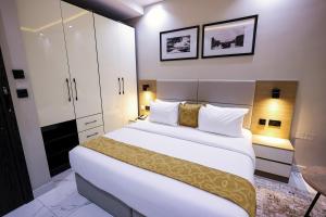 a bedroom with a large white bed and cabinets at Ringruby Hotel, Oduduwa Way in Ikeja