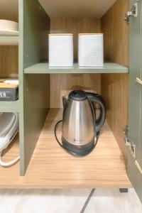 a tea kettle sitting on a shelf in a cupboard at Conforto e Estilo - RJ2-05 in Maringá
