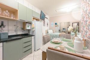 a kitchen and living room with a table and a dining room at Conforto e Estilo - RJ2-05 in Maringá