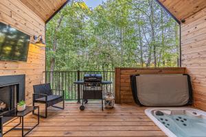 a screened in porch with a tub and a tv at The Ash - Private Cabin with Hot Tub Oasis for Two in the Pines in Broken Bow