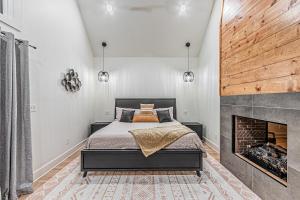 a bedroom with a bed and a fireplace at The Ash - Private Cabin with Hot Tub Oasis for Two in the Pines in Broken Bow