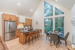 a kitchen with a island and a table with chairs at The Ash - Private Cabin with Hot Tub Oasis for Two in the Pines in Broken Bow