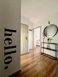 a living room with a mirror and a wooden floor at Klimatyczny apartament Złotniki in Wrocław