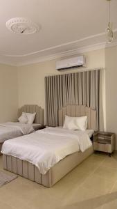 a bedroom with two beds and a air conditioner at HomeSuiet in Jeddah