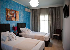 a hotel room with two beds and a window at Serenita Apartments in Ermones