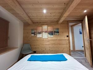 ein Schlafzimmer mit einem Bett und einer Holzwand in der Unterkunft Appartement rénové au cœur de Morillon pour 6 pers. - FR-1-642-89 in Morillon