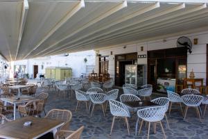 eine Terrasse mit Tischen und Stühlen und ein Gebäude in der Unterkunft GEORGIOS L in Skopelos