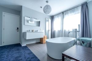 un bagno bianco con vasca e lavandino di Hotel Temse a Temse