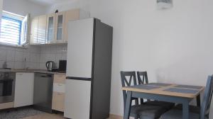 a kitchen with a table and chairs and a refrigerator at Apartment Marina in Srima
