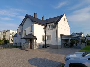 a large white house with a driveway at Kwatery Prywatne Majka in Władysławowo
