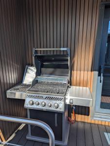 a barbecue grill sitting on a deck next to a building at Houseboat 19 20 Sneekermeer in Offingawier