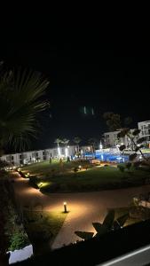 a night time view of a park with a pool at Prestigia plage des nations in Sale +2 photos