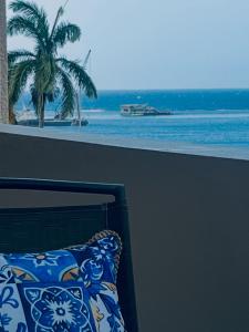 a balcony with a view of the ocean and a palm tree at Millie's Paradise - Bay Beach Ocho Rios in Ocho Rios