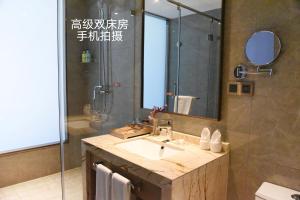 a bathroom with a sink and a shower with a mirror at Nanjing Grand View Hotel in Nanjing +6 photos