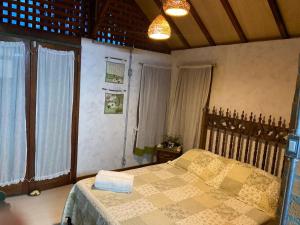 a bedroom with a bed in a room with windows at Villa da Serra in Águas da Prata +49 photos